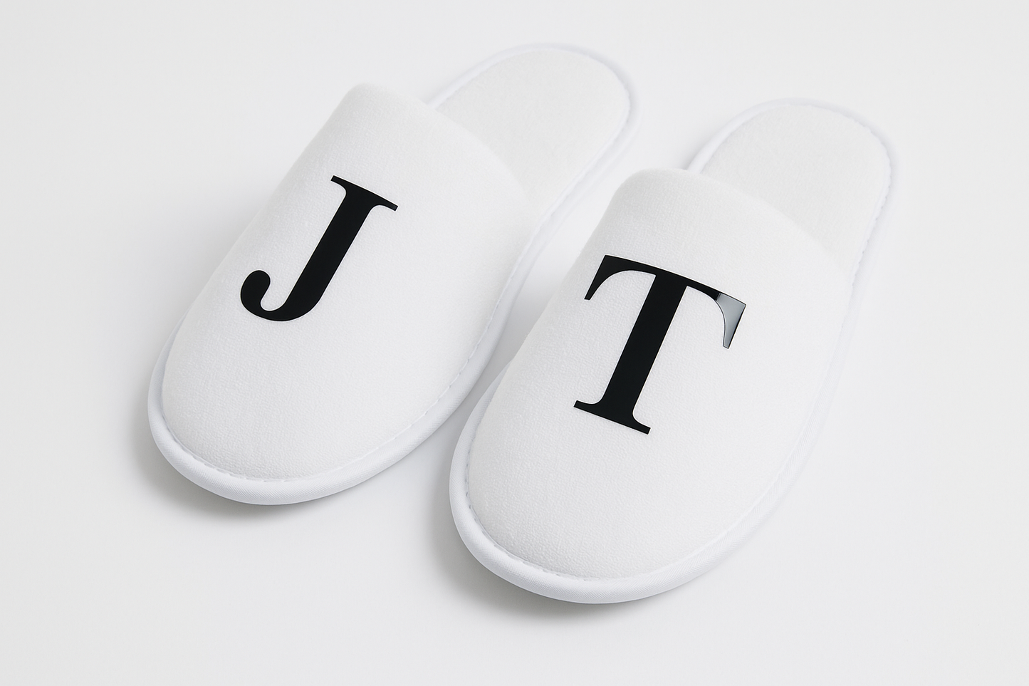 White closed-toe wedding slippers with heat transfer vinyl initials J and T