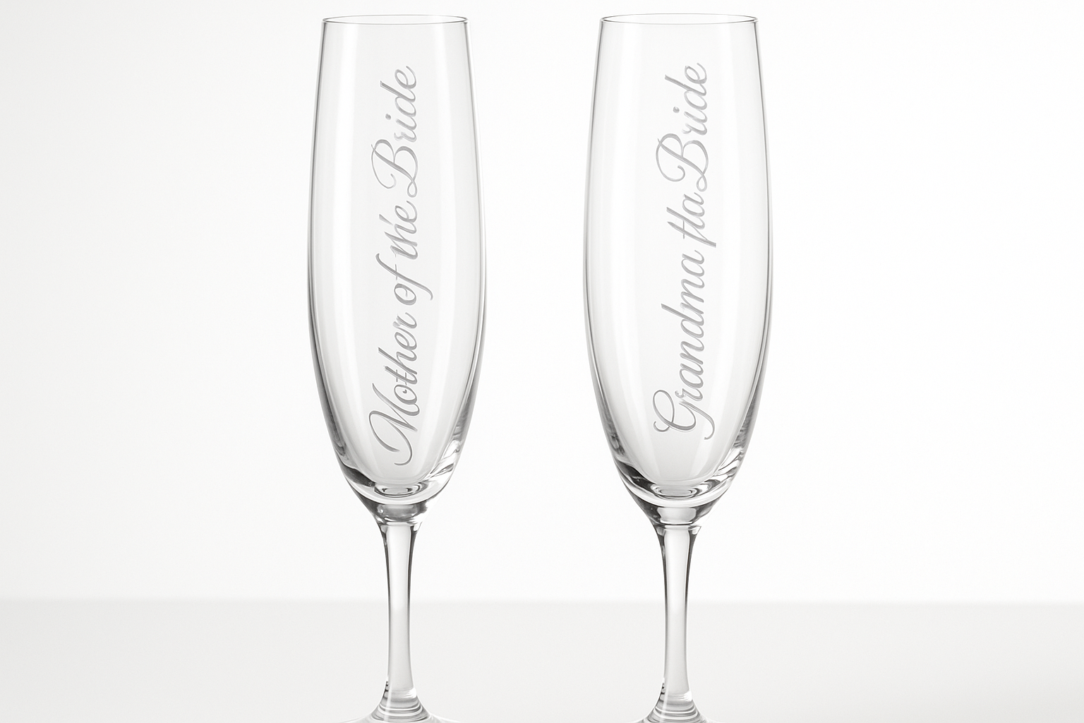 Two elegant champagne flutes with text etched vertically down the sides - Mother of the Bride and Grandma Of The Bride